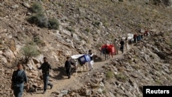 Afghan men lead donkeys loaded with ballot boxes and other election material to be transported to polling stations which are not accessible by road in Shutul, Panjshir province, Afghanistan, Sept. 27, 2019.