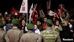 Pro-secular demonstrators wait for the release of former army chief Ilker Basbug outside the Silivri prison complex near Istanbul, Turkey, March 7, 2014.