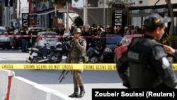 Un policier et un soldat montent la garde sur le site d'un attentat suicide près de l'ambassade américaine à Tunis, en Tunisie, le 6 mars 2020. (REUTERS/Zoubeir Souissi)