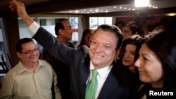 Costa Rica's ruling party candidate Johnny Araya (C) greets supporters next to his wife Sandra Leon (R) as he arrives for a news conference where he announced he was quitting the presidential race, in San Jose, Costa Rica, March 5, 2014.