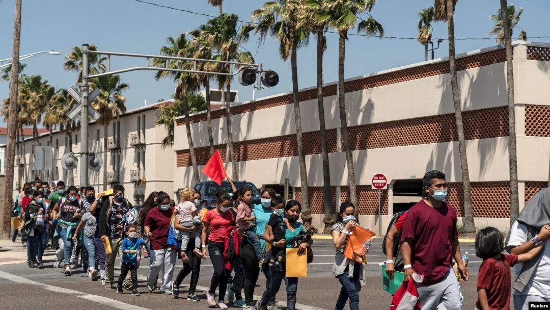 Familias de inmigrantes marchan hacia un albergue temporal en McAllen, Texas, EE. UU., el 8 de abril de 2021.