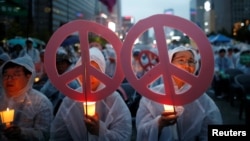 People attend a candlelight vigil wishing for a successful summit between the U.S. and North Korea, in front of the U.S. embassy in central Seoul, South Korea, June 9, 2018.