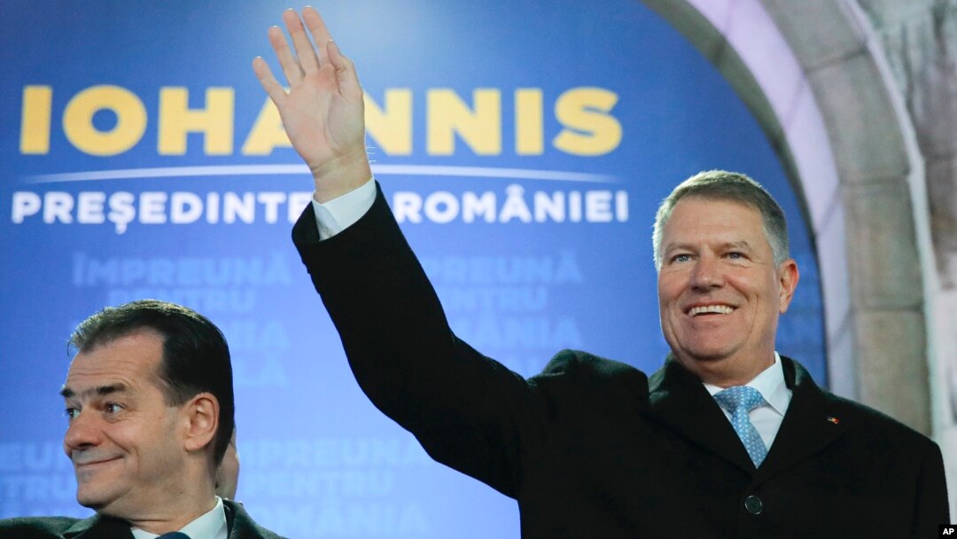 Presiden Romania Klaus Iohannis (kanan) melambaikan tangan didampingi Perdana Menteri Romania Ludovic Orban, di Bucharest, Romania, 24 November 2019. 