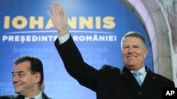 Presiden Romania Klaus Iohannis (kanan) melambaikan tangan didampingi Perdana Menteri Romania Ludovic Orban, di Bucharest, Romania, 24 November 2019. 