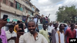 Des habitants de Port-Soudan célèbrent l'avancée, selon l’armée soudanaise, d’une force militaire et des groupes armés alliés sur Wad Madani, capitale de la province-clé d'Al-Jazira, tenue par les Forces de soutien rapide, le 11 janvier 2025.