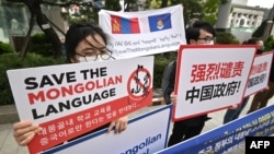 Ljudi drže plakate s natpisom "Spasite mongolski jezik" tokom skupa osuđujući kineski plan da uvede nastavu samo na mandarinskom jeziku u školama u Unutrašnjoj Mongoliji, poluautonomnoj regiji u Kini, Južna Koreja, septembar 24., 2020.