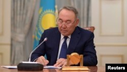 Kazakh President Nursultan Nazarbayev writes during a televised address to announce his resignation, in Astana, Kazakhstan, March 19, 2019.