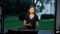 FILE - CNN White House correspondent Kaitlan Collins talks during a live shot in front of the White House, July 25, 2018.