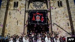 Brides and grooms pose for a photo outside Lisbon's Cathedral following their wedding ceremonies, in Lisbon, Portugal, June 12, 2019.