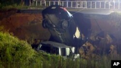 En esta imagen hecha a partir de video y proporcionada por WLOX-TV, se extrae un vehículo de un agujero en la autopista 26, el martes 31 de agosto de 2021, cerca de Lucedale, Mississippi (WLOX-TV vía AP)