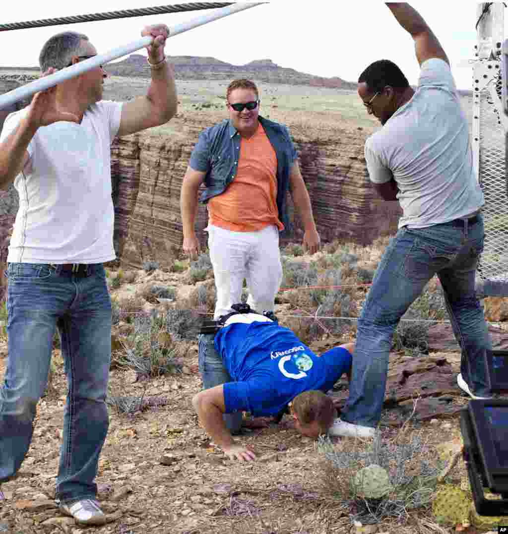 Aerialis Nik Wallenda mencium tanah setelah berhasil menyeberangi Grand Canyon. (AP/Discovery Channel, Tiffany Brown)