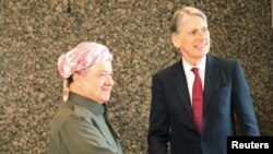 Iraq's Kurdistan region's President Massoud Barzani (L) shakes hands with Britain's Foreign Secretary Philip Hammond in Irbil, Iraq, March 17, 2016. 