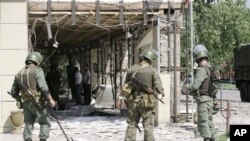 Security personnel stand guard at scene of suicide bombings in central Grozny, Chechnya, Aug. 31, 2011