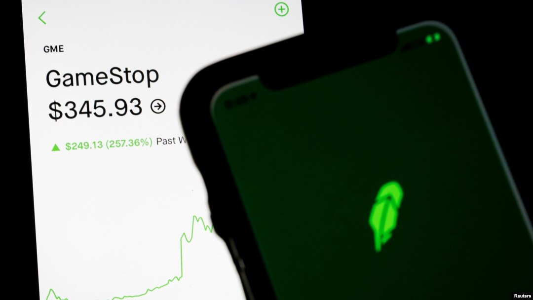 Trading information for GameStop is displayed on the Robinhood App as another screen displays the Robinhood logo in this photo illustration January 29, 2021. REUTERS/Brendan McDermid/Illustration