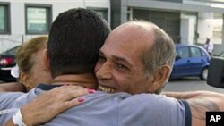 Freed Cuban prisoner Orlando Fundora Alvarez (R) is greeted by an unidentified Cuban after arriving at a hostel in Madrid, Apr 8 2011