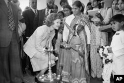 FILE—Four-year-old Prem, whose name means "Love" in Hindi, applies a spot of dry colored powder to the forehead of first lady Rosalynn Carter, left, at a boarding school in New Delhi, Jan. 2, 1978.