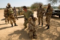 FILE - A U.S. special forces soldier demonstrates how to detain a suspect during Flintlock 2014, a U.S.-led international training mission for African militaries, in Diffa, Niger, March 4, 2014.