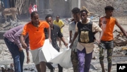 Tim penyelamat membawa jenazah seorang warga sipil yang tewas dalam ledakan di Mogadishu, Somalia, Rabu, 12 Januari 2022. (Foto: AP)