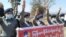 Полицейские с транспарантом салютуют, присоединившись к протесту против военного переворота в Мьянме