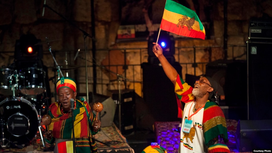Vivien Jones stands behind the drummers waving the Jamaican flag at the Jerusalem Sacred Music Festival. (Courtesy Hanan Bar Assulin/Jerusalem Season of Culture)
