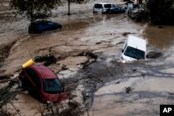 Voda odnosi automobile, nakon što su poplave koje su prethodile obilnim kišama dovele do izlivanja reke iz korita u gradu Alora u Malagi, Španija, 29. oktobar, 2024. (Foto: AP/Gregorio Marrero)