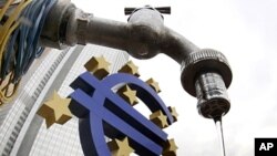 Water runs from a tap in front of the Euro sculpture at the European Central Bank in Frankfurt, Germany, December 1, 2011.