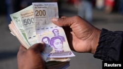 Un hombre muestra en Caracas los dos nuevos billetes que comienzan a circular paulatinamente como parte del cono monetario venezolano, de 200 y 500 bolívares, el 3 de septiembre de 2024.