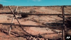 Une croix de pierres sous la clôture à laquelle était attaché Matthew Shepard, Laramie, Wyoming, le 9 octobre 1999.
