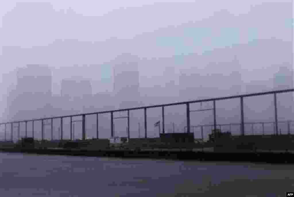 Lower Manhattan is shrouded in clouds in New York, Sunday, Aug. 28, 2011. Hurricane Irene bore down on a dark and quiet New York early Sunday, bringing winds and rapidly rising seawater that threatened parts of the city. The rumble of the subway system wa