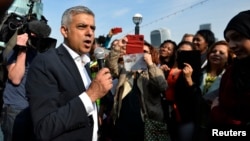 Britain's newly elected mayor Sadiq Khan speaks to supporters as he arrives for his first day at work at City Hall in London, May 9, 2016.