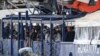 Des migrants se tiennent sur le pont du navire de sauvetage Humanity 1, géré par l'organisation allemande SOS Humanitarian, dans le port de Catane, en Sicile, dans le sud de l'Italie, dimanche 6 novembre 2022. (AP Photo/Salvatore Cavalli)