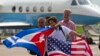 FILE - Passengers of JetBlue Flight 387 holding U.S. and Cuban flags pose for photos in front of the plane transporting U.S. Transportation Secretary Anthony Foxx, at the airport in Santa Clara, Cuba, Aug. 31, 2016.