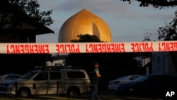 A police officer stands guard in front of the Al Noor Mosque in Christchurch, New Zealand, March 17, 2019, where one of the two mass shootings occurred. New Zealanders reached out to Muslims around the country Saturday, determined to show kindness to a community in pain.