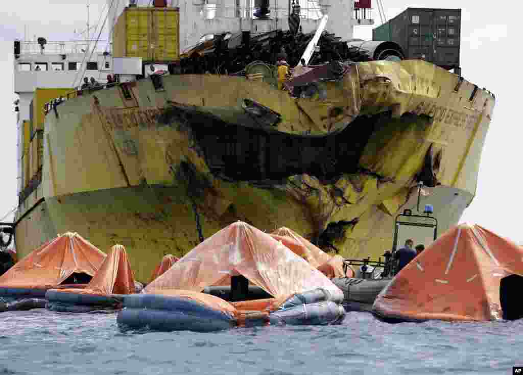 A cluster of life rafts floats near the cargo ship Sulpicio Express Siete a day after it collided with a passenger ferry off the waters of Talisay city, Cebu province in central Philippines. Divers combed through a sunken ferry to retrieve the bodies of more than 200 people still missing from an overnight collision.