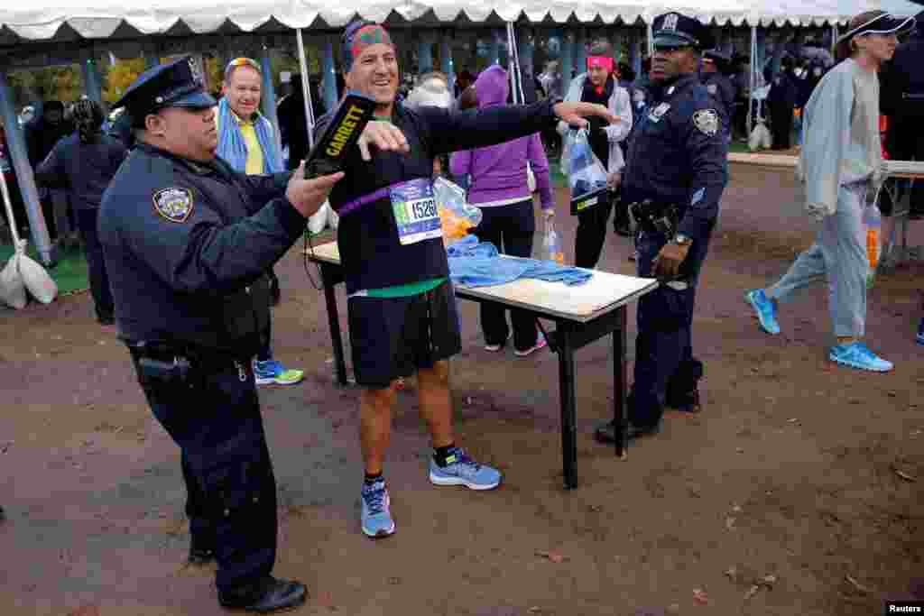 Police conduct security checks as runners check in for the New York City Marathon. 