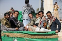 FILE - Armed Houthi followers ride on the back of a truck after a funeral of Houthi fighters killed in recent clashes with government forces in Yemen's oil-rich province of Marib, in Sanaa, Yemen, Feb. 20, 2021.
