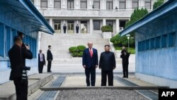 Lãnh tụ Triều Tiên Kim Jong Un và TT Mỹ Donald Trump tại khu phi quân sự phân cách hai miền của bán đảo Triều Tiên ở Bàn Môn Điếm, ngày 30/6/2019. (Photo by Brendan Smialowski /AFP)