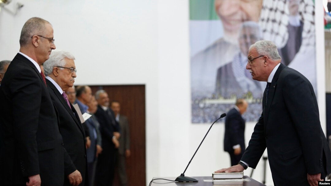 Menlu Palestina Riyad al-Maliki (kanan) mengambil sumpah jabatan di hadapan Presiden Palestina Mahmoud Abbas dalam pelantikan pemerintahan persatuan di Ramallah (2/6).