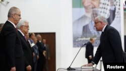 Menlu Palestina Riyad al-Maliki (kanan) mengambil sumpah jabatan di hadapan Presiden Palestina Mahmoud Abbas dalam pelantikan pemerintahan persatuan di Ramallah (2/6).