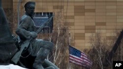 Boys cover their faces with plastic bags while pushing a handcart during rainfall in Peshawar, Pakistan.