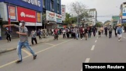 8일 미얀마 북부 도시 미치나에서 열린 군부 쿠데타 반대 시위 현장에서 참가자들이 부상자를 대피시키고 있다.