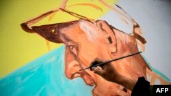 El artista peruano Daniel Manrique trabaja en un mural que representa a Lizardo Jiménez, de 80 años, víctima de COVID-19 en el cerro San Cristóbal en Lima el 15 de julio de 2020.
