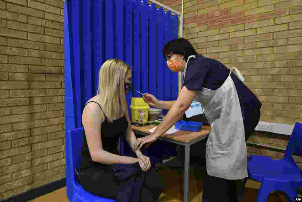 ساؤتھ ویلز کے ہیلتھ سینٹر میں کام کرنے والی ایک ملازمہ کو ویکسین دی جارہی ہے۔ 