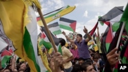 Palestinians dance and sing prior to the arrival of Palestinian President Mahmoud Abbas at the government compound, in the West Bank city of Ramallah, September 25, 2011.