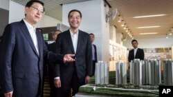 Zhang Dejiang (l) chairman of China's National People's Congress, and Hong Kong Chief Executive Leung Chun-ying (r) look at a model of newly built public housing blocks due to open later this year in Hong Kong on May 19, 2016. 