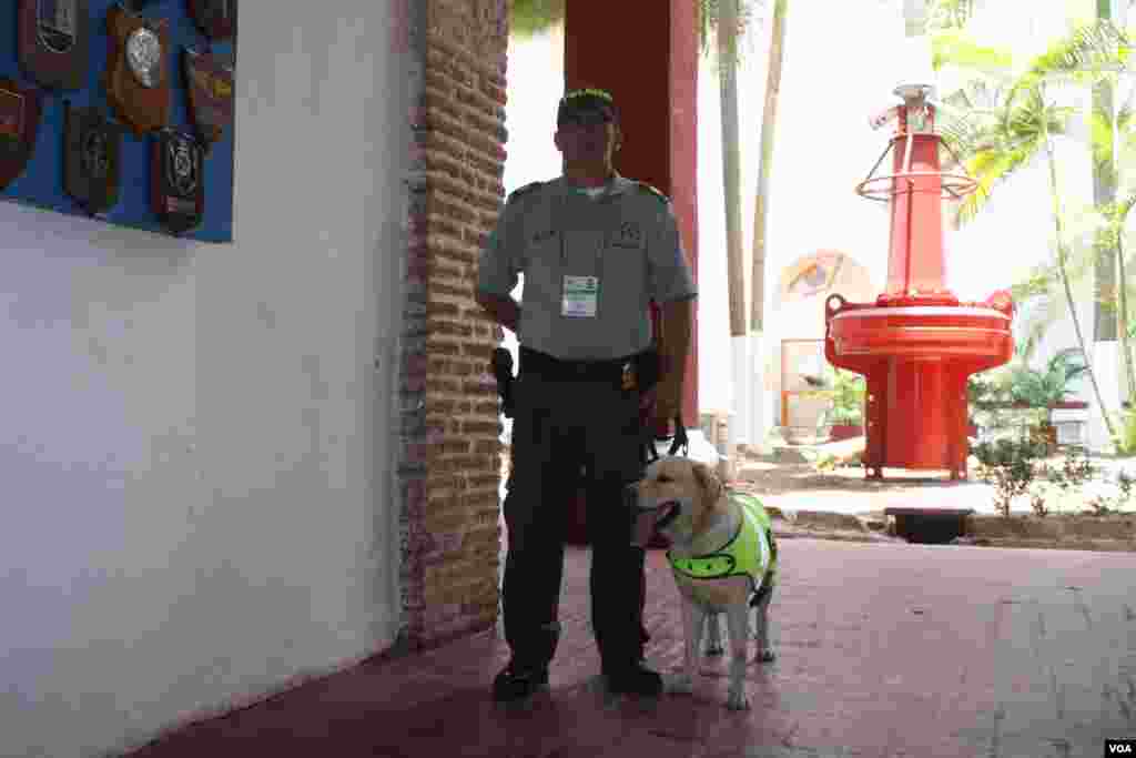 Un oficial de polic&iacute;a y su perro en el centro de bienvenida en Cartagena.&nbsp; (Iscar Blanco, VOA)