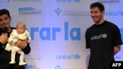 Lionel Messi, à droite, ambassadeur itinérant de football de l'Unicef, sourit à Azul Urrutia, un bébé né prématurément, lors du lancement de la campagne "Semaine de la prématurité", à Ezeiza, Buenos Aires, le 21 mars 2013.