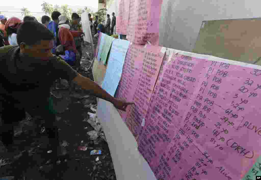 A resident checks the names of his missing relatives in New Bataan township, Compostela Valley, Philippines, December 6, 2012. 