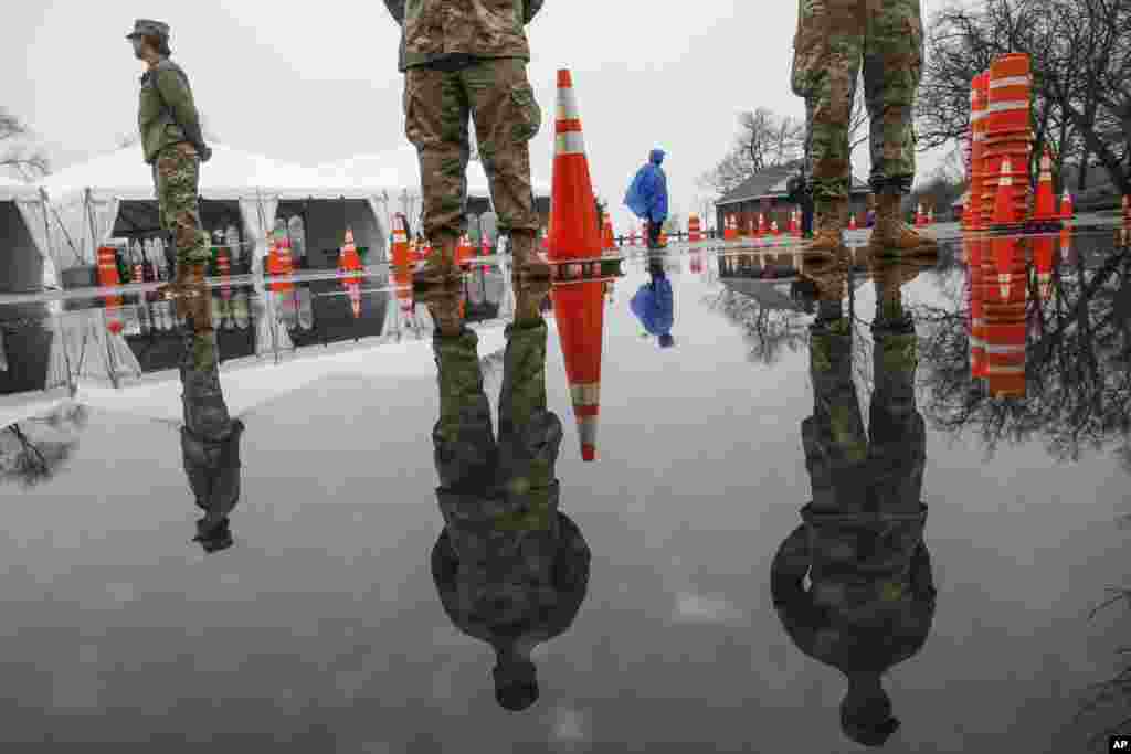 National Guard personnel stand at attention as they wait for patients to arrive for COVID-19 coronavirus testing facility at Glen Island Park, in New Rochelle, N.Y.