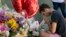 Paolo Singer, 27, a Silver Lake resident, prays at a makeshift memorial of flowers, candles and notes on the sidewalk outside the Silver Lake Trader Joe's store in Los Angeles, July 23, 2018. Trader Joe's employee Melyda Corado was shot and killed at the store in a gunfight Saturday between a gunman and police. 